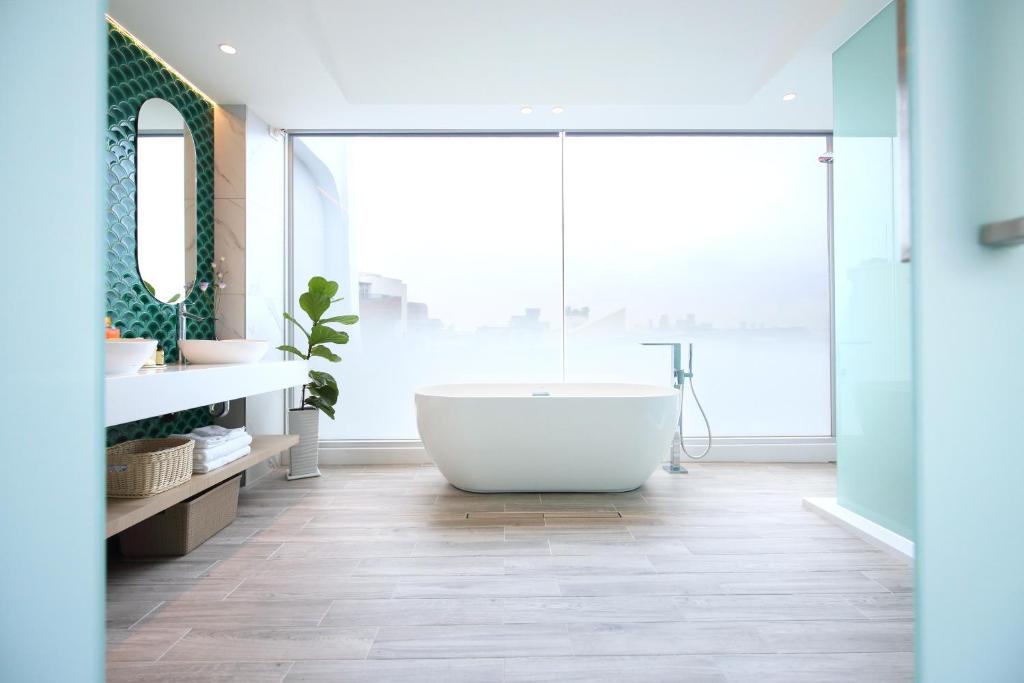 ein Bad mit einer Badewanne und einem großen Fenster in der Unterkunft Fleur Villa in Hualien