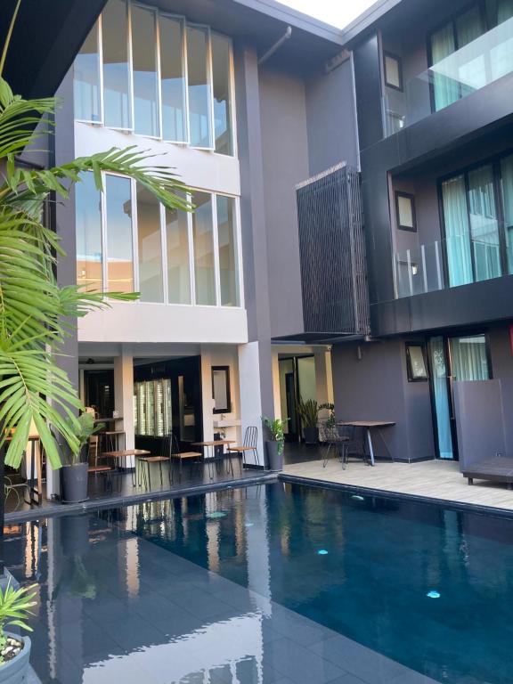 A close view of the courtyard pool beside shaded seating and tall hotel windows.