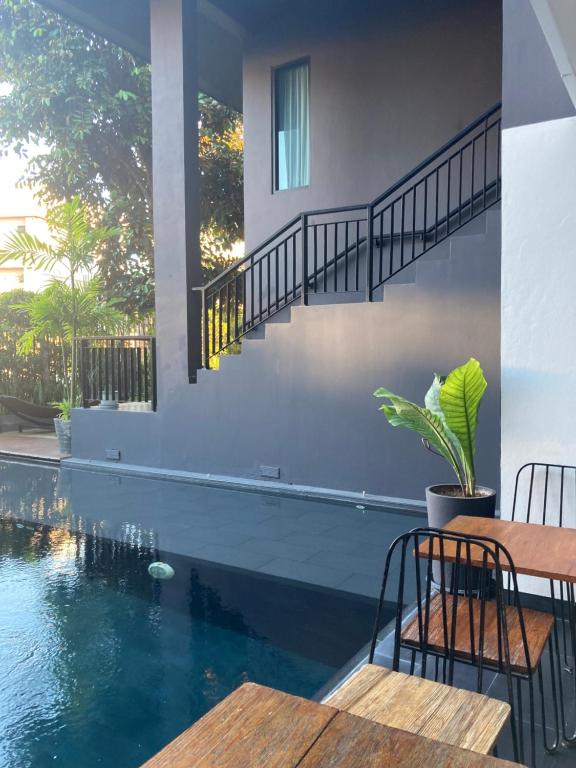 A compact outdoor pool beside a shaded patio and exterior staircase.