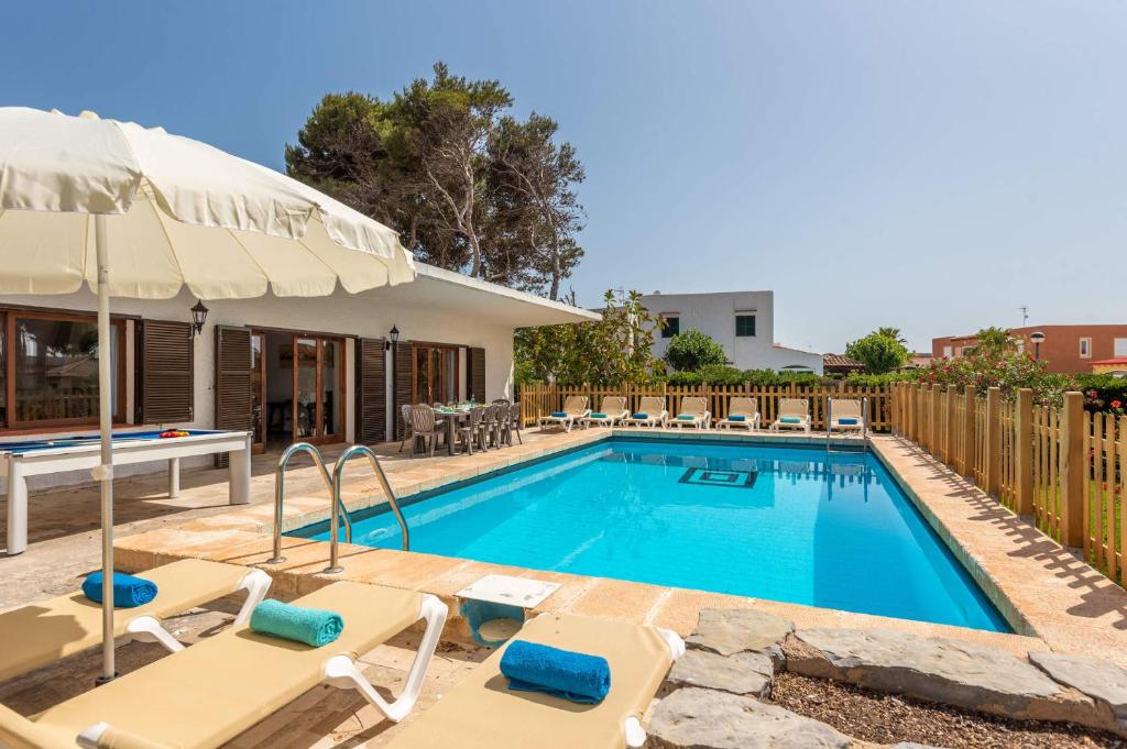 a swimming pool with chairs and an umbrella at Villa Es Pins by Villa Plus in Son Carrio