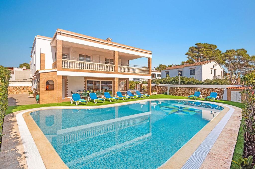 a house with a swimming pool in front of a house at Villa Maria Isabel in Cala Blanca