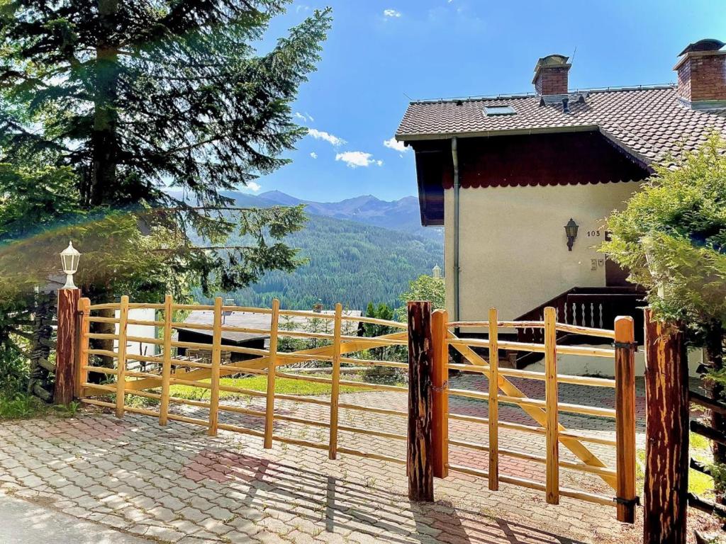 a wooden fence in front of a house at Ferienhaus mit Zirbitzblick in Mönchegg