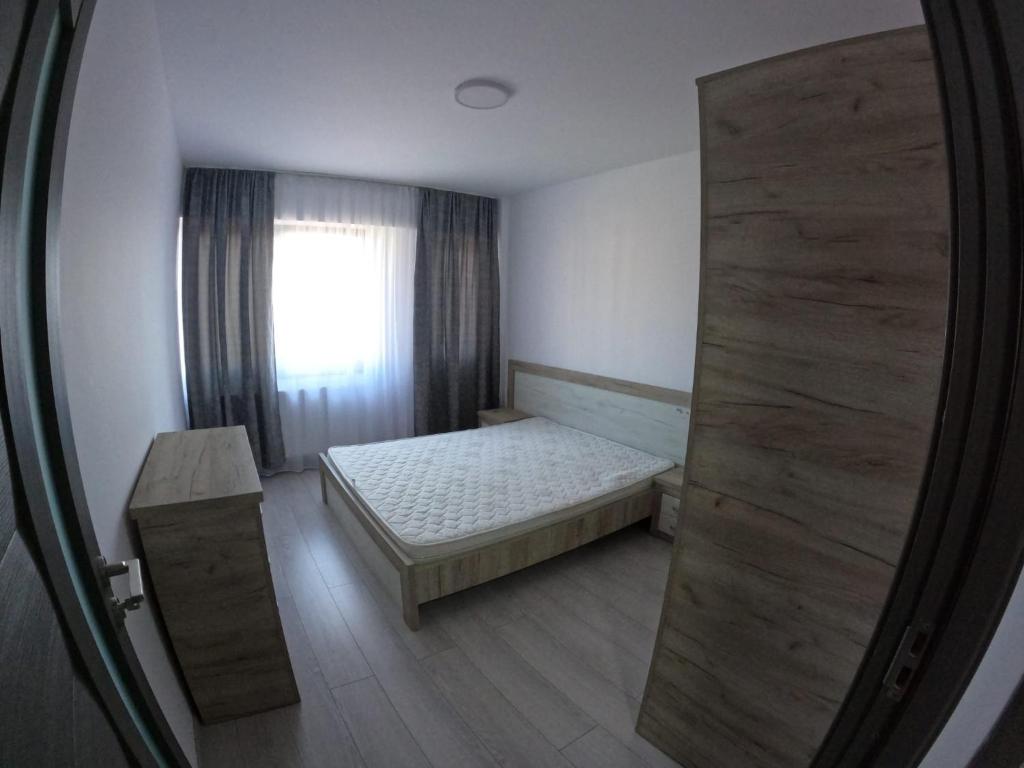 a small bedroom with a bed and a window at Cazare bloc nou ultracentral in Râmnicu Vâlcea