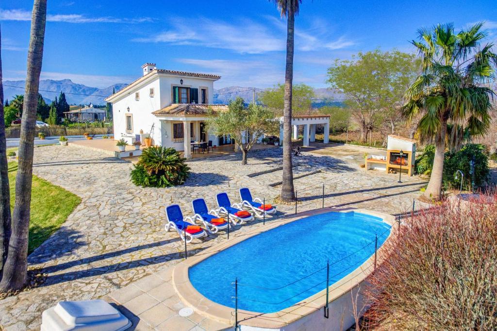 a swimming pool with chairs and a house at Villa Can Idu by Villa Plus in El Port
