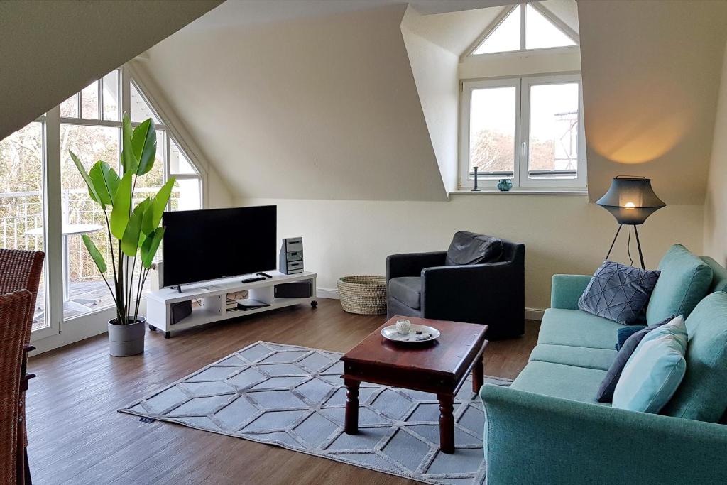 a living room with a blue couch and a tv at Villa Seepferdchen Wohnung 10 in Kühlungsborn
