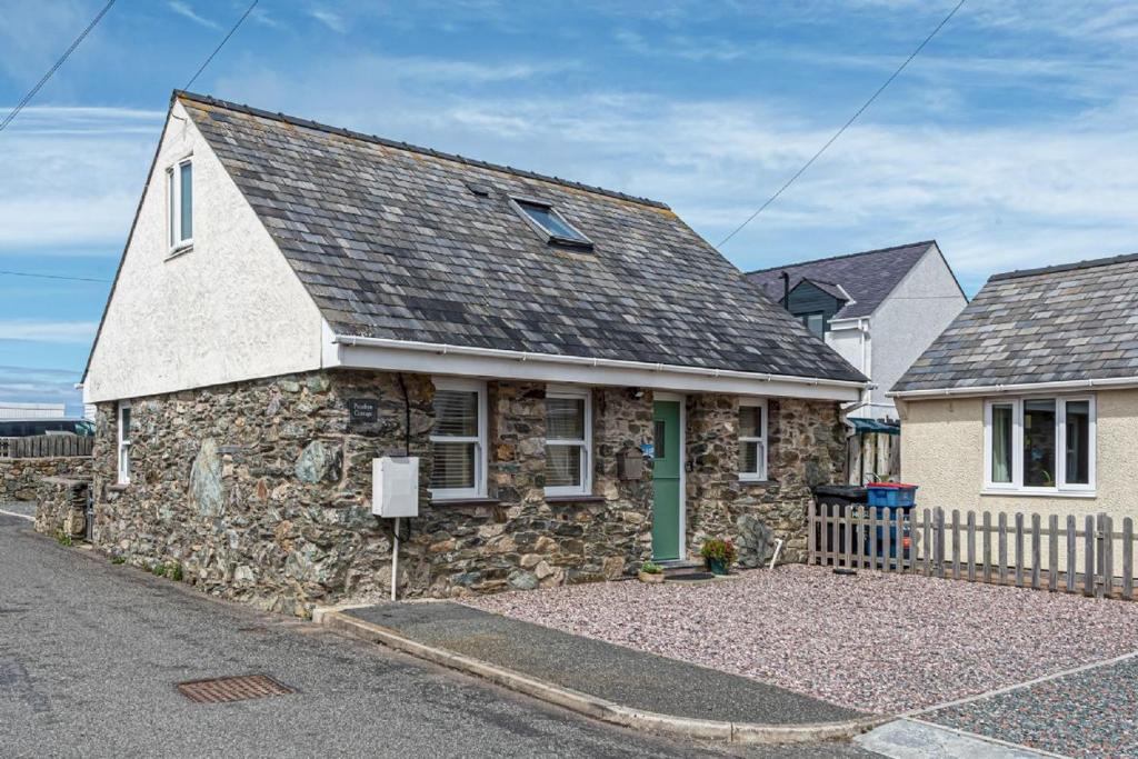 a stone house on the side of a street at Penrhyn Cottage in Cemaes Bay