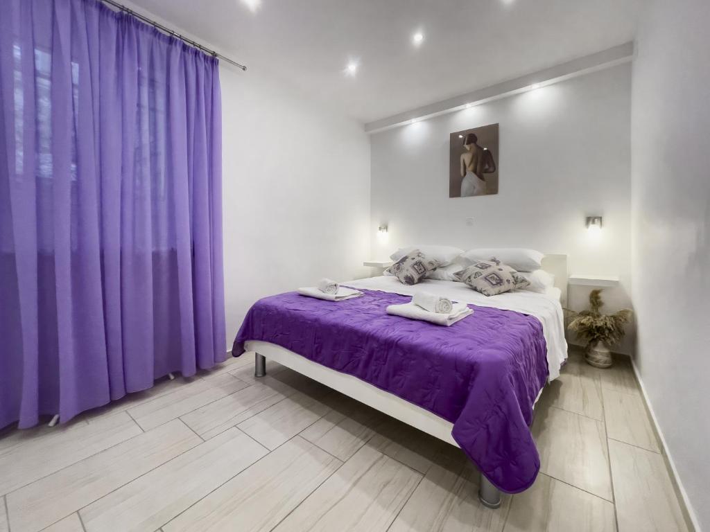 a bedroom with purple curtains and a large bed at Apartment Pink in Split