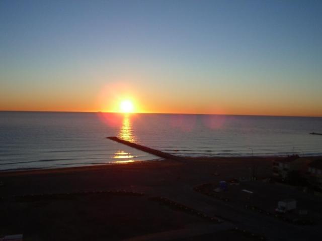 una puesta de sol en la playa con la puesta de sol sobre el océano en MAGNIFICO ATICO-DUPLEX FRENTE AL MAR, en El Puig