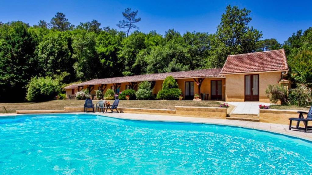 une maison avec une piscine devant une maison dans l'établissement Ferme Auberge Du Roc, à Les Vauries