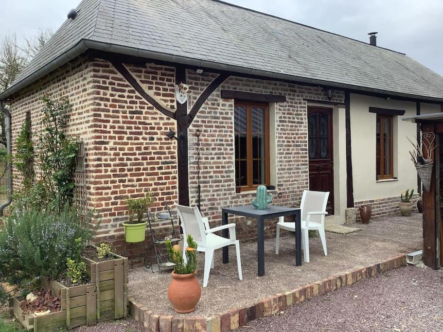 una piccola casa in mattoni con tavolo e sedie di Gîte à la campagne a Saint-Léger-du-Gennetey