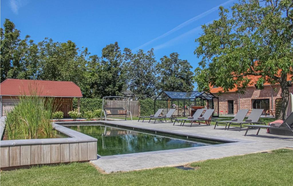 een zwembad in een tuin met stoelen eromheen bij Cozy Home In Diksmuide With Outdoor Swimming Pool in Diksmuide