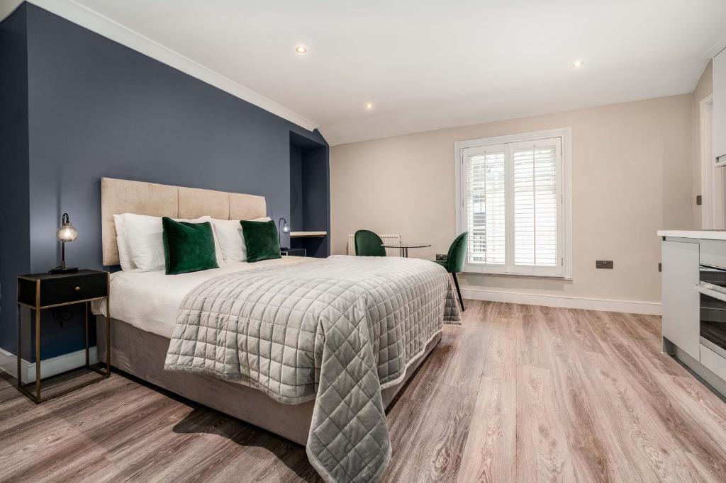 1 dormitorio con 1 cama grande con almohadas verdes en The Regent, en Cambridge