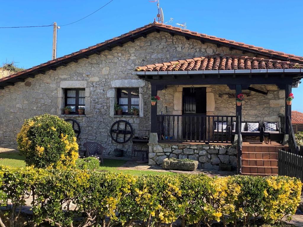 een stenen huis met een veranda en een balkon bij Casa Las Hortensias 2 Pendueles in Llanes