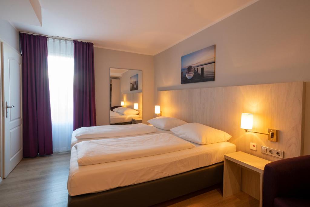 a hotel room with two beds and a window at Nautic Hotel Bremerhaven in Bremerhaven