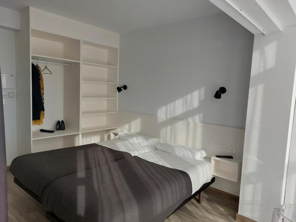 A bed or beds in a room at Pensión Amorrortu Lemona