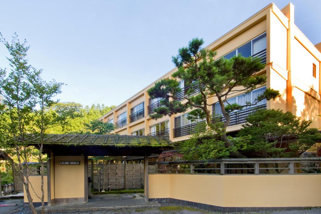 an apartment building with a tree in front of it at Nikko Hoshino Yado in Nikko