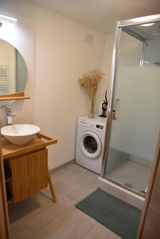 a bathroom with a washing machine and a washer at Le refuge de la Sallée in Gençay
