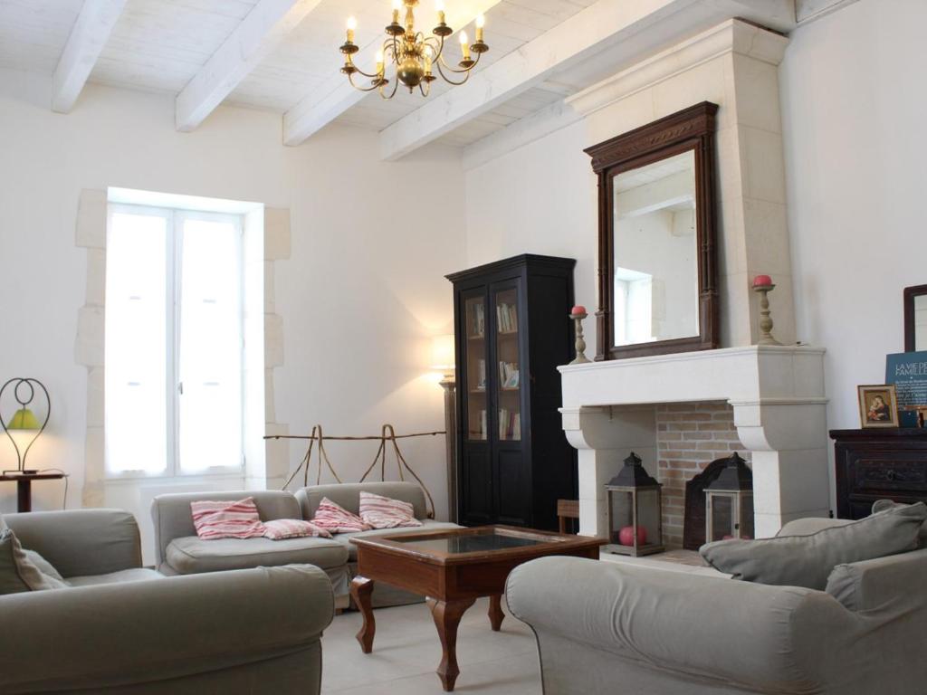 een woonkamer met 2 banken en een open haard bij Maison Saint-Georges-d'Oléron, 10 pièces, 15 personnes - FR-1-246A-61 in Saint-Georges-dʼOléron