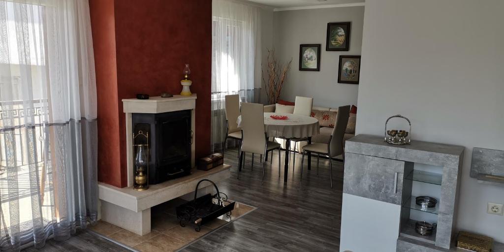 ein Wohnzimmer mit Kamin und ein Esszimmer in der Unterkunft Апартамент При Рени in Kopriwschtiza