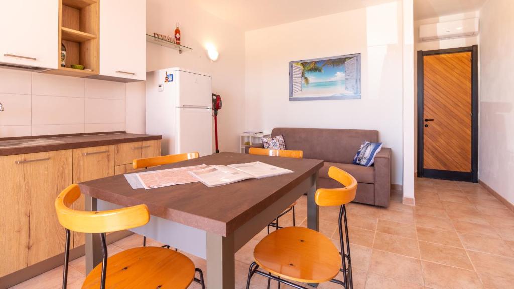 cocina con mesa y sillas en una habitación en Welcomely - A due passi dal Mare nel Sinis, en Funtana Meiga