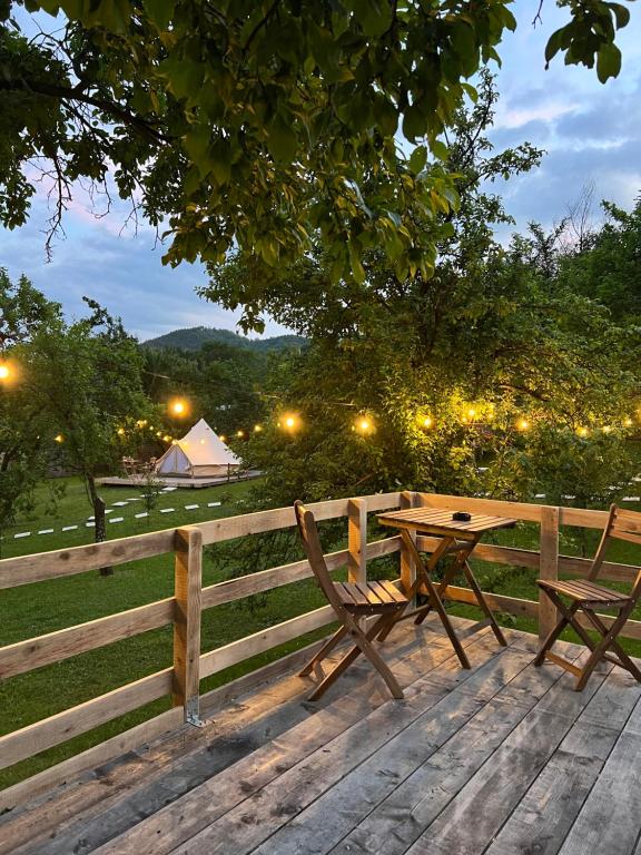 a wooden table and bench next to a fence at Tinutul Luanei Glamping Resort in Bozioru