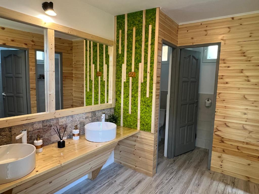 a bathroom with two sinks and a mirror at Tinutul Luanei Glamping Resort in Bozioru