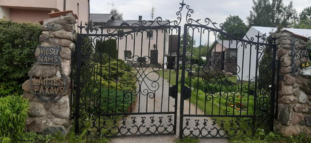 una puerta a una casa con jardín en viesu nams "Laimes pakavs" en Straupe