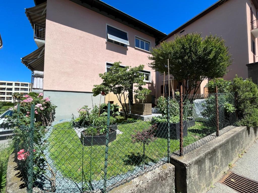una valla frente a una casa con árboles en Sweet Home 3 bedrooms free parking, en Lugano