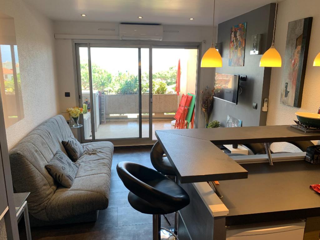 a living room with a couch and a table at Antibes Secured Parc Velusine with private parking, Terrace, Pools and Tennis courts. in Antibes