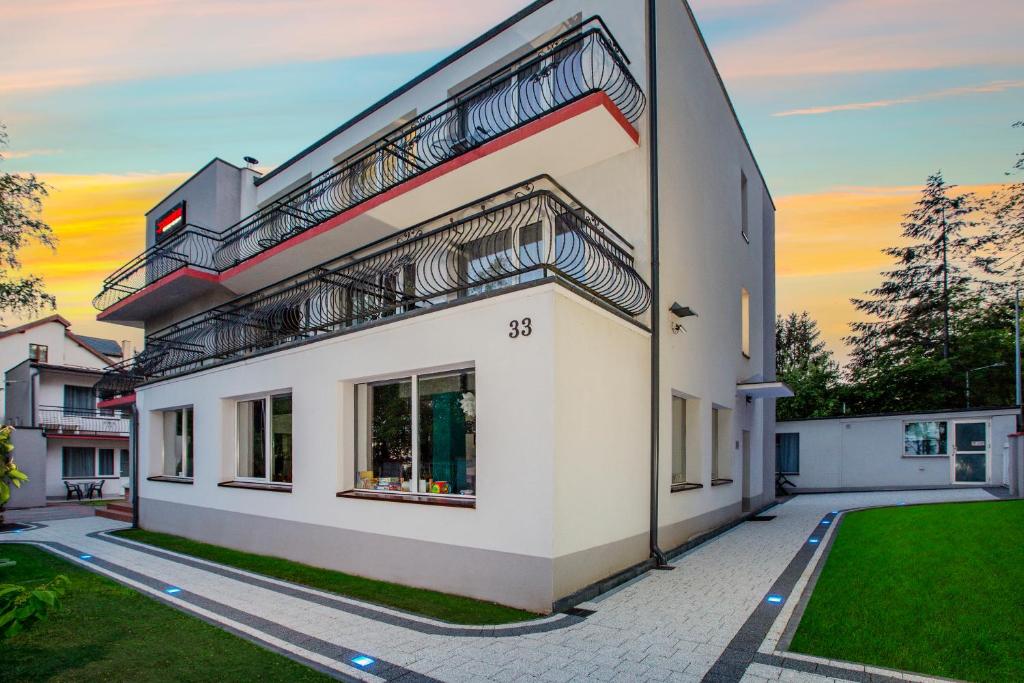 Ośrodek Wypoczynkowy CHAMPION في فواديسوافوفو: مبنى أبيض مع شرفة على الجانب