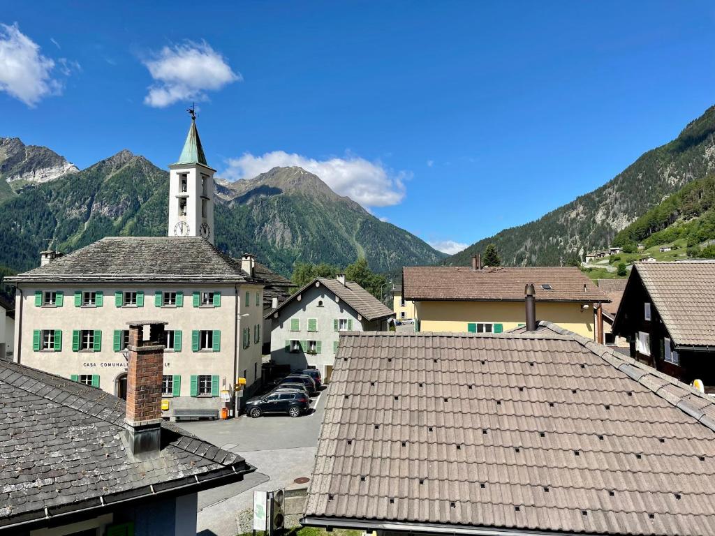 a view of a village with a church and mountains at Casa Bella Oschesina by Quokka 360 - Charming Stay in the Village of Osco in Osco