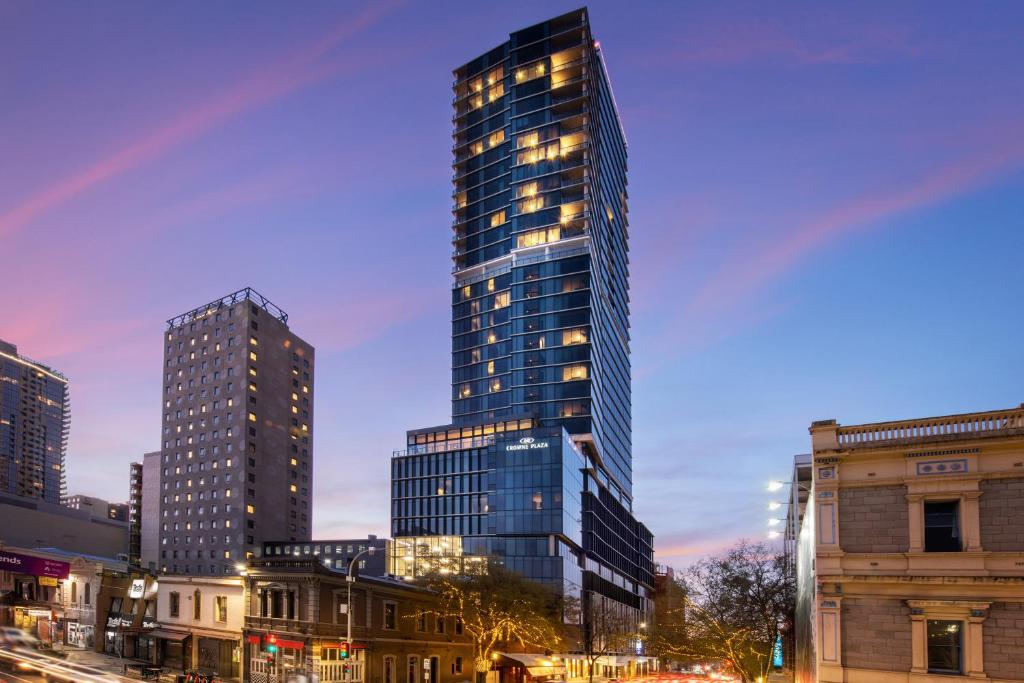 un grand bâtiment éclairé dans une ville dans l'établissement Crowne Plaza Adelaide, an IHG Hotel, à Adélaïde