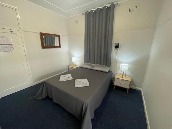 a room with a bed with two lamps on it at The Pink House in Walgett