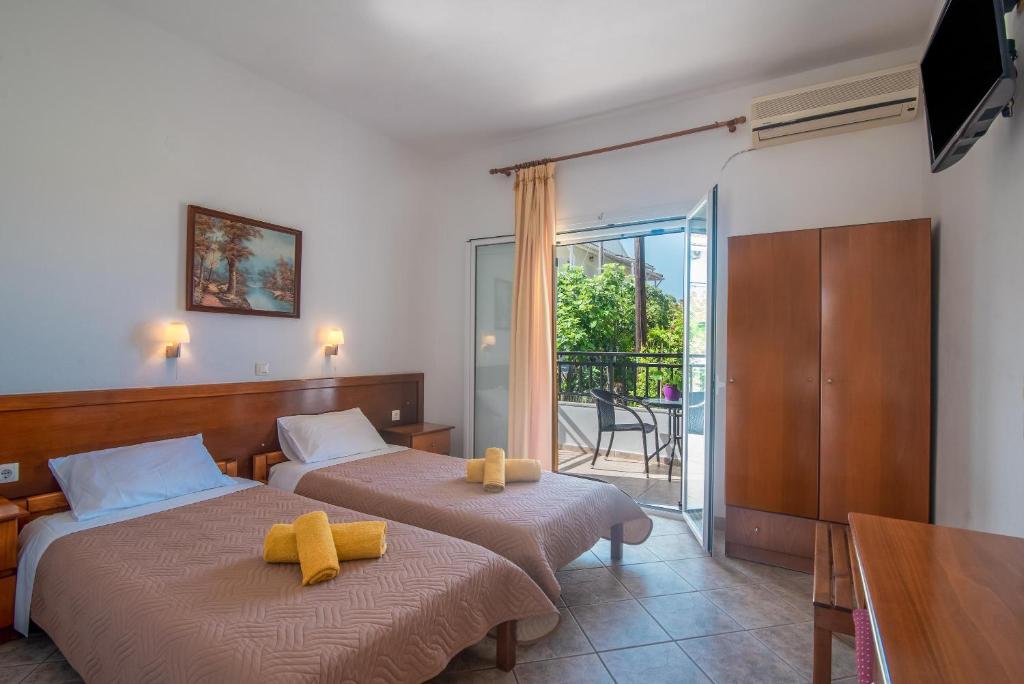 two beds in a room with a balcony at Aleka Apartment 1 in Agios Georgios