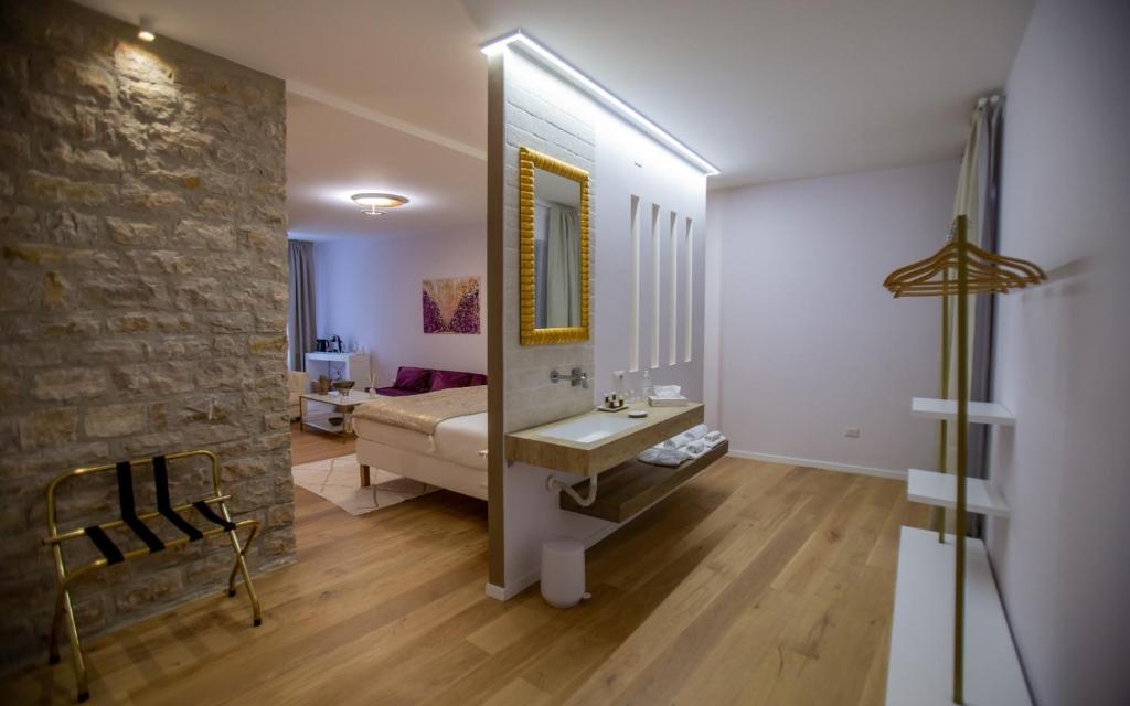 a bathroom with a sink and a stone wall at La Piazzetta Suite in Potenza