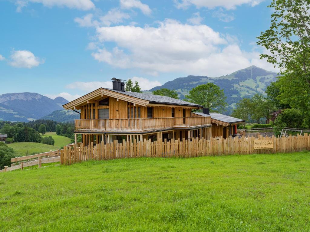 een houten huis in een veld met een hek bij Penning.Tirol in Hopfgarten im Brixental