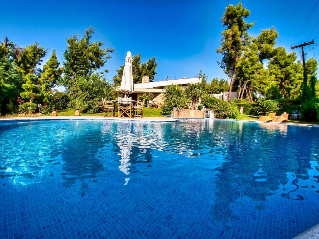 a large swimming pool in front of a house at Sani Forest Luxury Villa in Sani Beach
