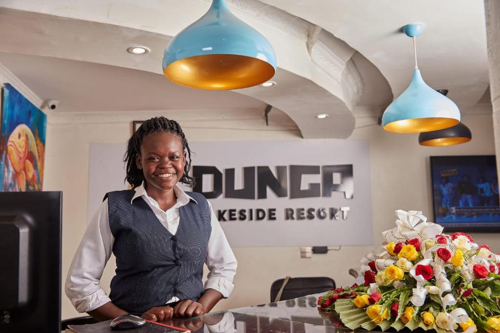 a woman standing in front of a table with flowers at Dunga LakeSide Resort in Kisumu