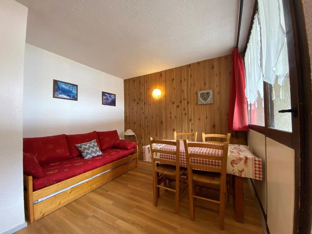 ein Wohnzimmer mit einem roten Sofa und einem Tisch in der Unterkunft Studio Lanslevillard, 1 pièce, 3 personnes - FR-1-508-266 in Lanslevillard