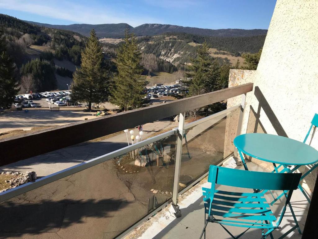une chaise et une table bleues sur un balcon avec vue dans l'établissement Studio cabine à Villard-de-Lans, pour 4 pers, parking gratuit - FR-1-515-139, à Villard-de-Lans