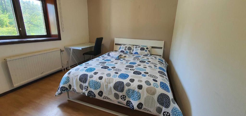 Schlafzimmer mit einem Bett mit einer blauen und weißen Bettdecke in der Unterkunft Private Room in Shared House-Close to University and Hospital-3 in Umeå