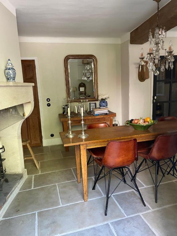 una sala da pranzo con tavolo e specchio di L'aile du Chateau a Ramatuelle