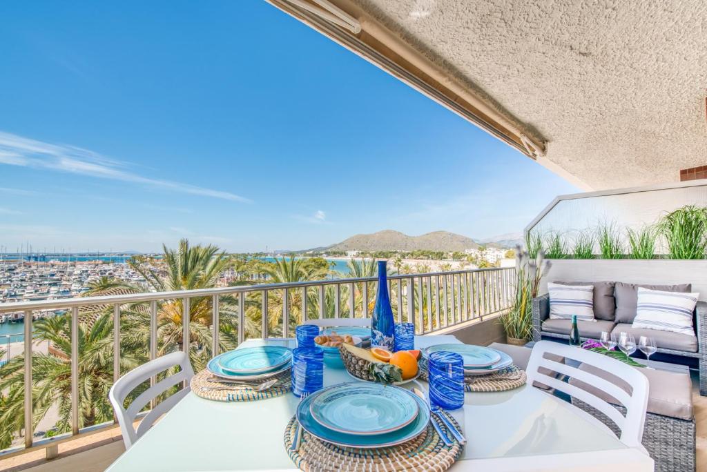una mesa y sillas en un balcón con vistas al océano en Ideal Property Mallorca - Blue Sky, en Alcudia