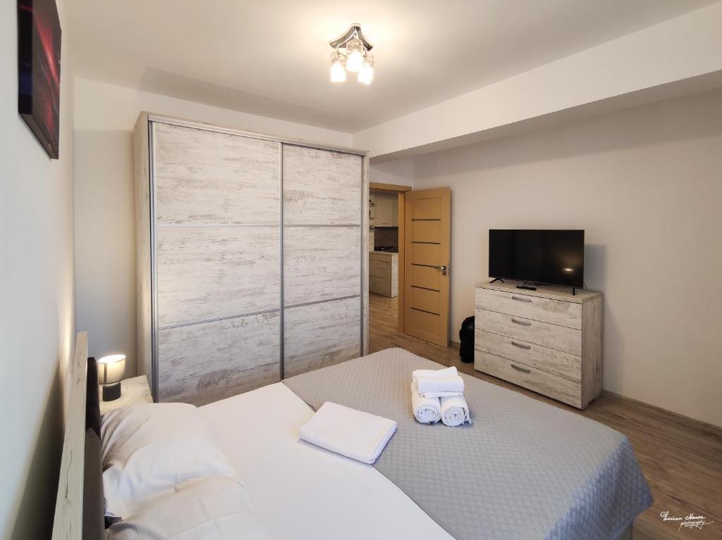 a bedroom with a white bed and a television at SARA Moonlight Residence in Mamaia