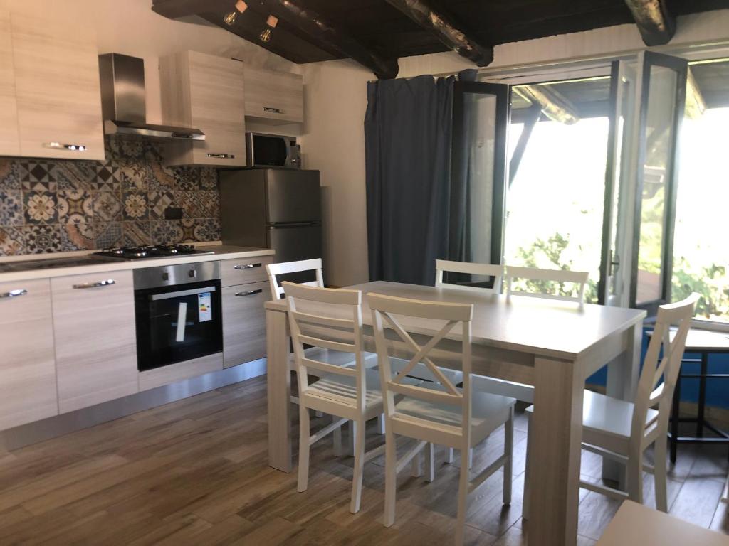 een keuken met een eettafel en stoelen bij Casa il Tramonto del Cilento in Scario