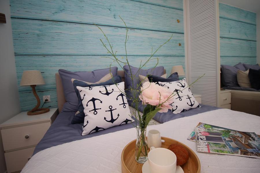 - un vase avec une fleur sur un lit et des oreillers dans l'établissement Morskie klimaty - Rejs, à Świnoujście