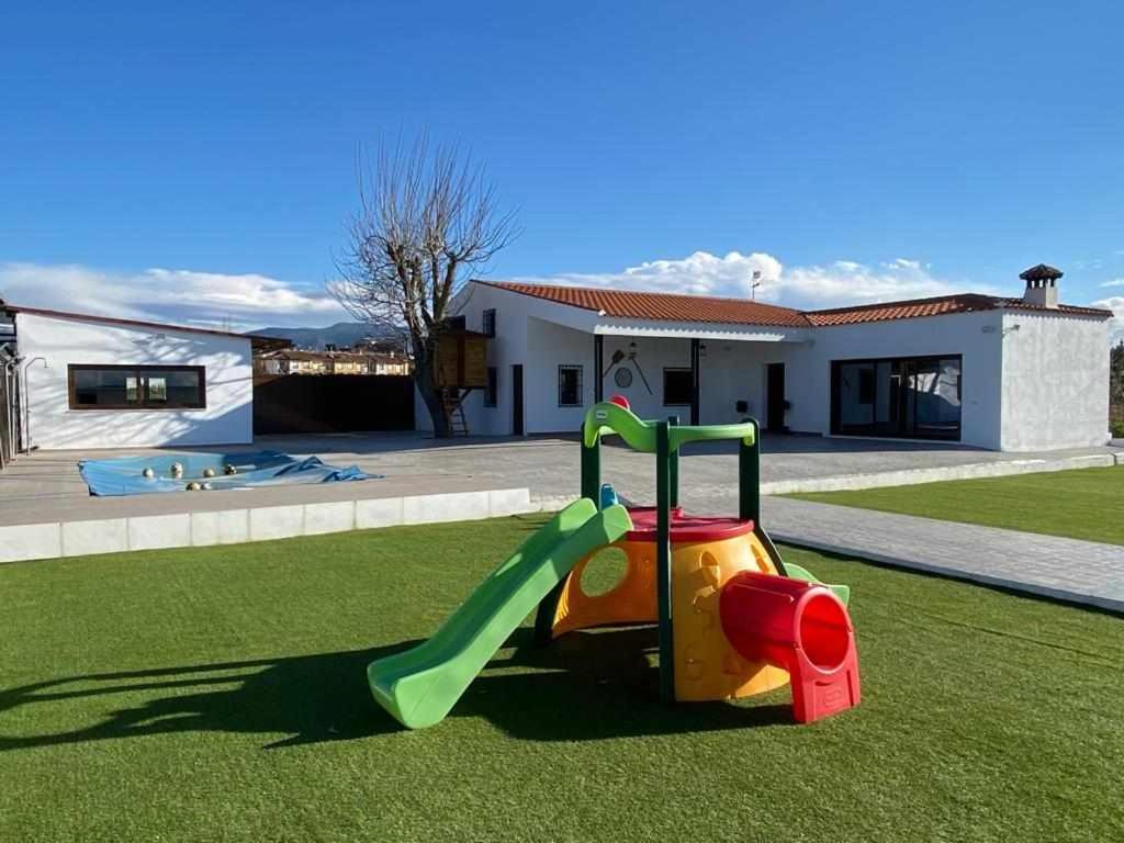 a childs slide in the grass in front of a house at El cortijo del abuelo pepe in Alhendín