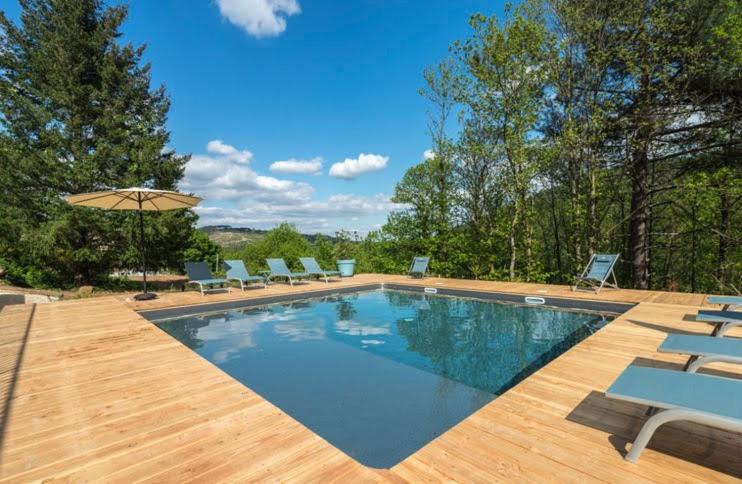 una piscina con sillas y sombrilla en Villa de Blanche nº 2, en Ribes