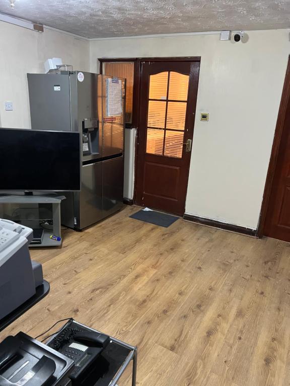 an empty room with a kitchen and a refrigerator at Affordable Suites in Summerseat