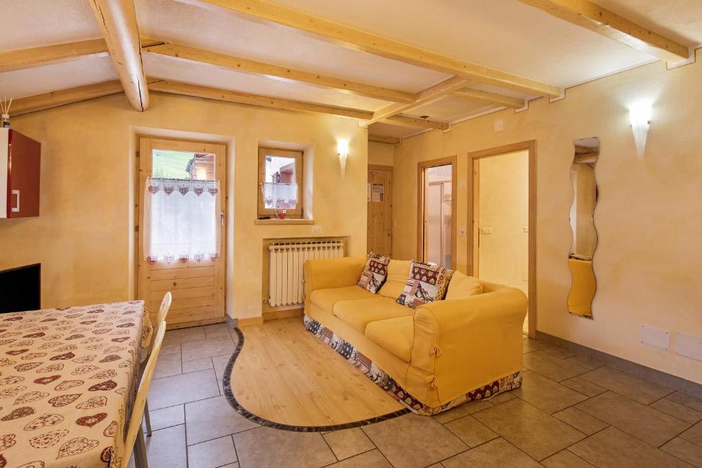un soggiorno con divano giallo e tavolo di Appartamento Giada a Livigno